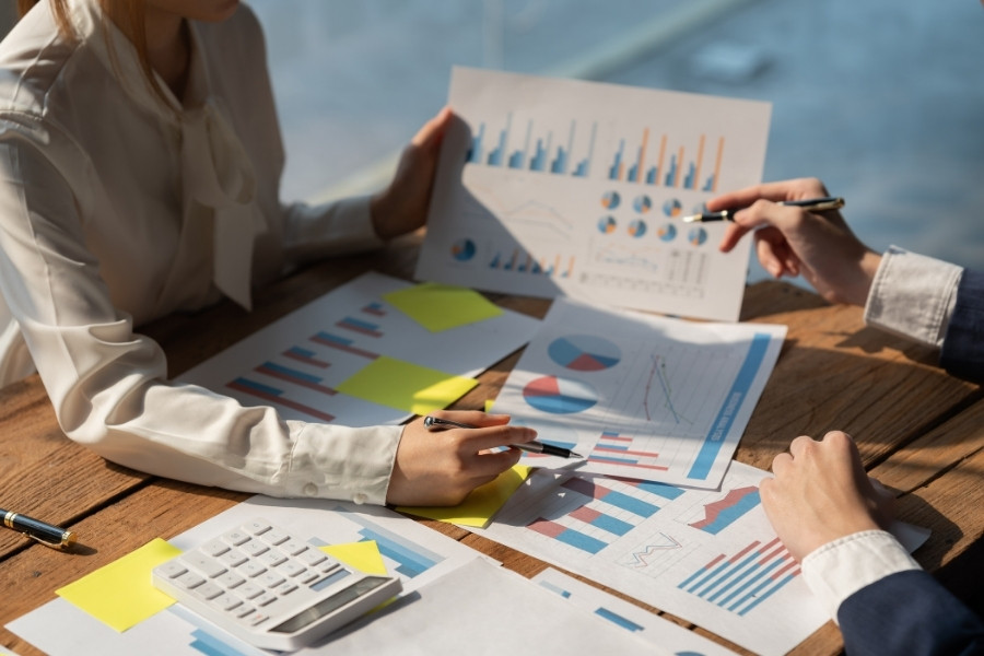 Hình ảnh minh họa hai nhân viên đang báo cáo tiến độ công việc phòng Marketing